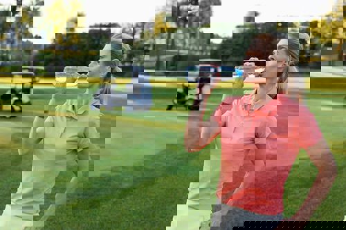 woman-drinking-water-on-golf-course